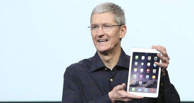 Apple CEO Tim Cook holds an iPad during a presentation at Apple headquarters in Cupertino